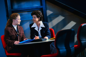 Photograph of two women conferring at a table.